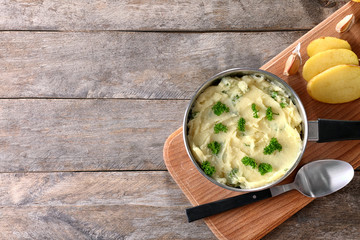Composition with mashed potatoes in sauce pan on table