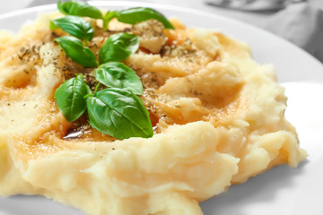 Mashed potatoes with basil and gravy on plate, closeup