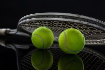 Close up of fluorescent yellow tennis balls with racket