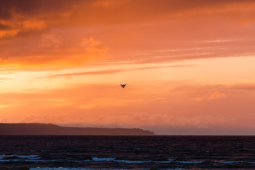 Flying drone over sea and cloud sky