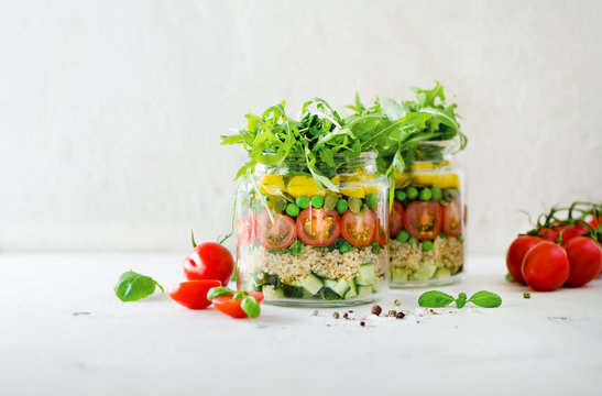Healthy salad jar with quinoa and vegetables, cherry tomatoes, cucumber, ruccola. Raw vegetarian meal for diet, detox, clean eating. Homemade concept