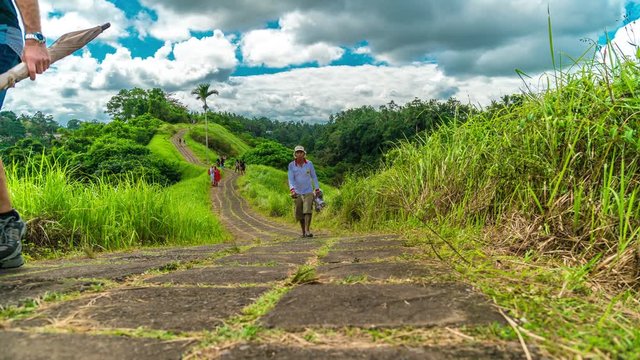 Time-lapse of running clouds and people walking along the trail of the artist in Ubud on the island of Bali in Indonesia. UBUD, INDONESIA - Jule, 2017