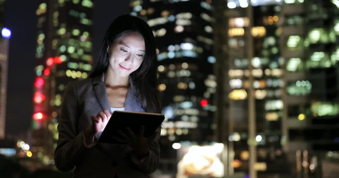 Businesswoman using digital tablet at night