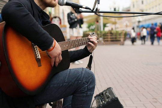 A street musician playing the guitar.