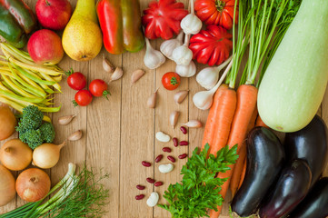 Eggplant, carrots, tomatoes, zucchini and other vegetables and fruits on a wooden table