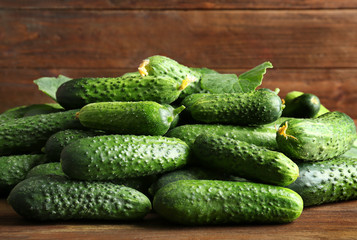 Many green fresh cucumbers on wooden table