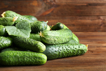Many green fresh cucumbers on wooden table