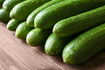 Many green fresh cucumbers on wooden table