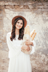 cute young girl carries bread in her hands