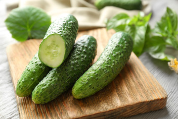Green fresh cucumbers on wooden board