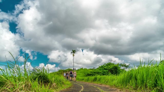 Time-lapse of running clouds and people walking along the Campuhan Ridge Walk in Ubud on the island of Bali in Indonesia. UBUD, INDONESIA - Jule, 2017
