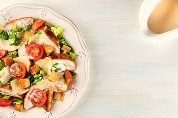 Chicken Caesar salad on light background with copyspace