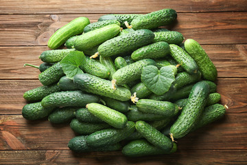 Many green fresh cucumbers on wooden background