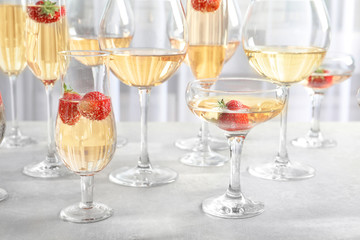 Glasses of delicious wine with strawberry on table