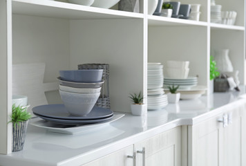 White storage stand with ceramic dishware in kitchen