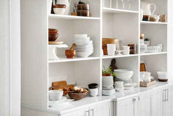 White storage stand with ceramic and wooden dishware in kitchen