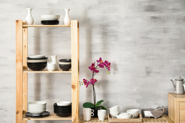Fototapeta na wymiar Modern kitchen interior with wooden storage stand and ceramic dishware