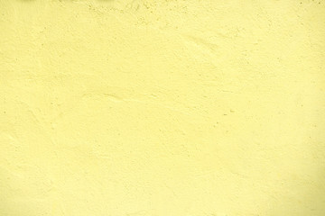 Textures of pastel yellow painted grunge concrete background