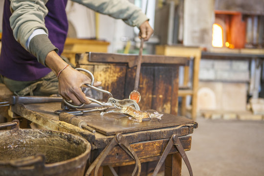 Midsection of glassblower working in workshop