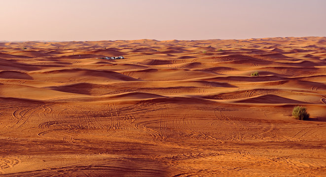 Desert safari vehicles at sunset in the sand dunes outside Dubai City, United Arab Emirates