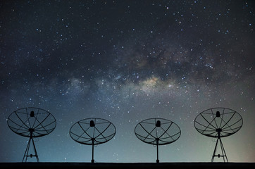 Satellite dishes on building for telecommunication with milky way sky background