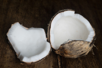 Closeup of ripe half coconut isolated on wooden table background