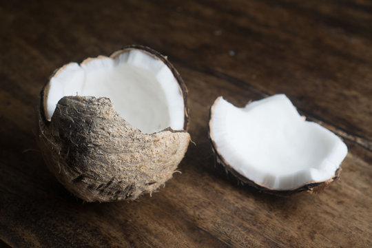 Closeup of ripe half coconut isolated on wooden table background