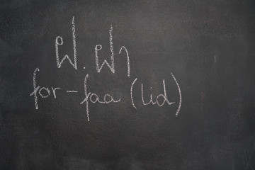 Obraz premium Thai letter written with white chalk on blackboard