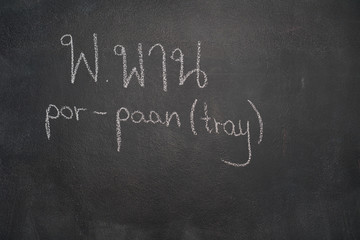 Fototapeta premium Thai letter written with white chalk on blackboard