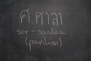 Fototapeta na wymiar Thai letter written with white chalk on blackboard