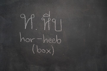 Thai letter written with white chalk on blackboard