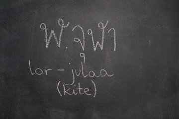 Thai letter written with white chalk on blackboard