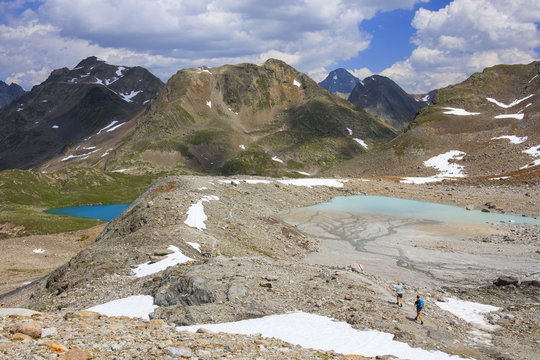 Hikers among turquoise lakes and rocky peaks in summer Joriseen J&ouml;rifless Pass canton of Graub&uuml;nden Engadin Switzerland Europe