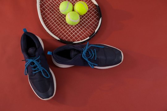 Overhead View Of Blue Sports Shoes By Tennis Racket And Balls