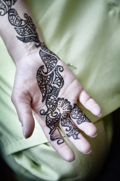A hand with a painted henna tattoo