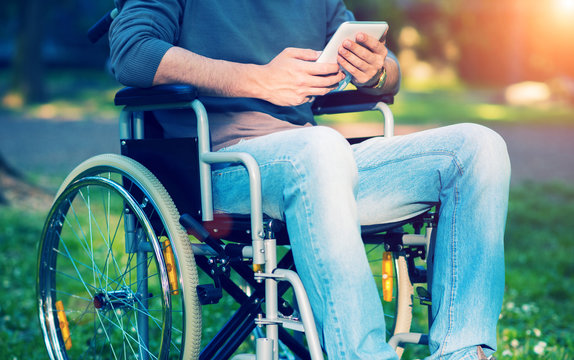 Man using a tablet on his wheelchair, filtered image