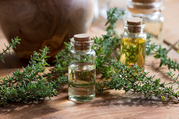 A bottle of thyme essential oil with fresh thyme twigs