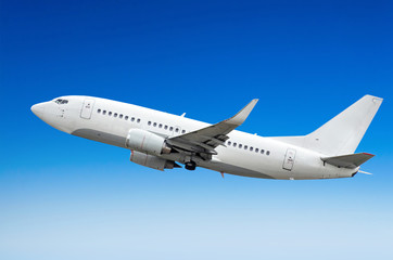 Passenger airplane flies in the sky gaining height above the clouds