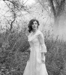 Fototapeta na wymiar lady in gorgeous vintage white dress in the forest. Black and white.