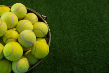 High angle view of fluorescent tennis balls in bucket