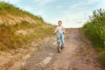 Smiling little girl on a bicycle