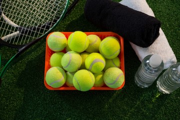 Overhead view of tennis balls in container amidst rackets and