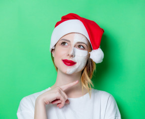 Fototapeta na wymiar Woman using eye patch for her eyes in Santa Claus hat