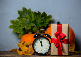 alarm clock with leaves and pumpkin with Halloween gift box