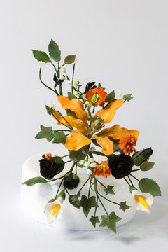 Edible floral cake display made from flower paste. On white background.