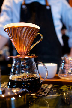 A copper coffee dripper on top of a coffee pot.
