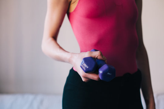 Woman in sportswear holding a set of weight