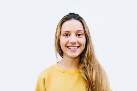 Blonde teen girl over white background looking at camera.