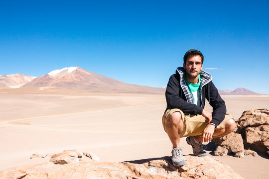 Adult man sitting against of scenic landscape