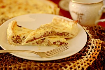 Mushroom quiche on white plate with silver fork